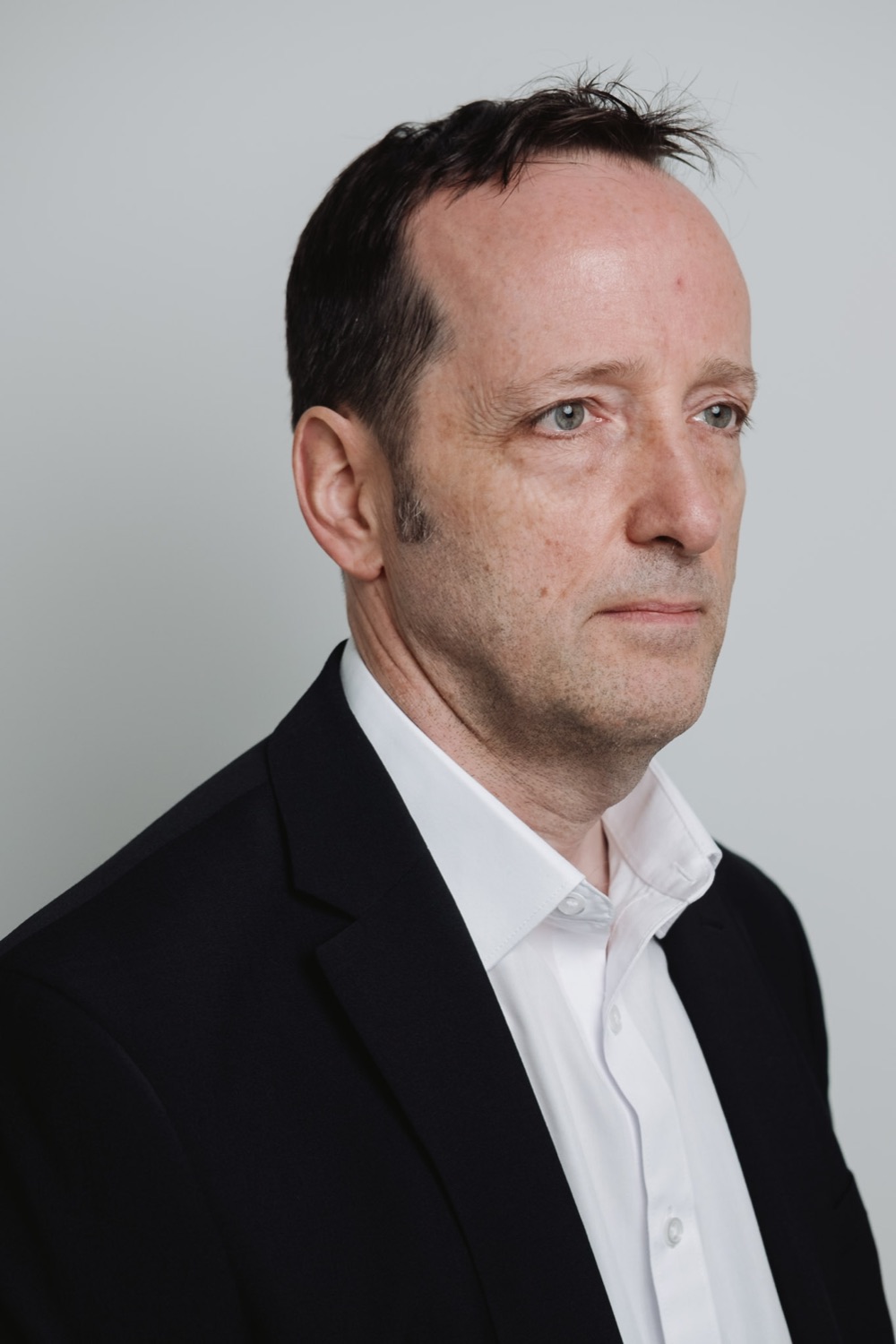 Executive headshot of a man in a dark suit, three-quarter angle