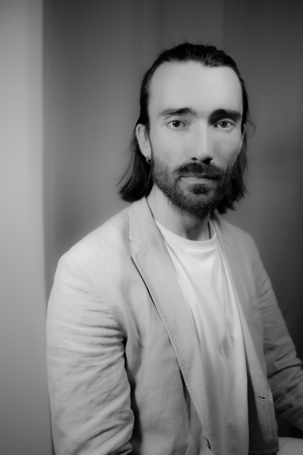 Black and white professional headshot of Konrad in a linen jacket